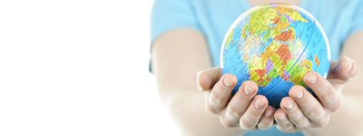 A person with outstretched arms holding a small globe of the world in their hands.